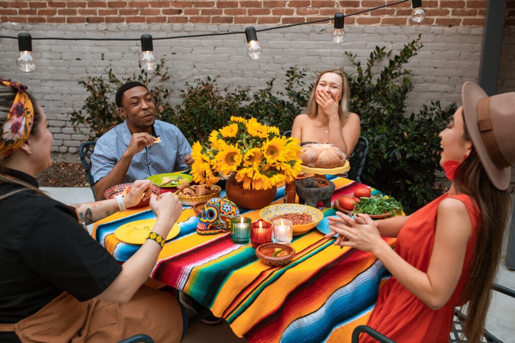 A diverse group of individuals gathered around a table, enjoying a meal together, representing cultural diversity.